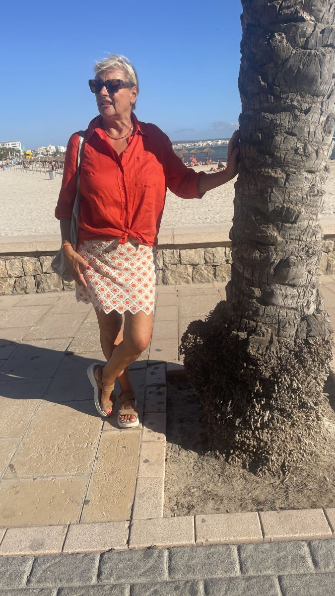 Claudia am Strand an eine Palme gelehnt - wo könnte es noch schöner sein?