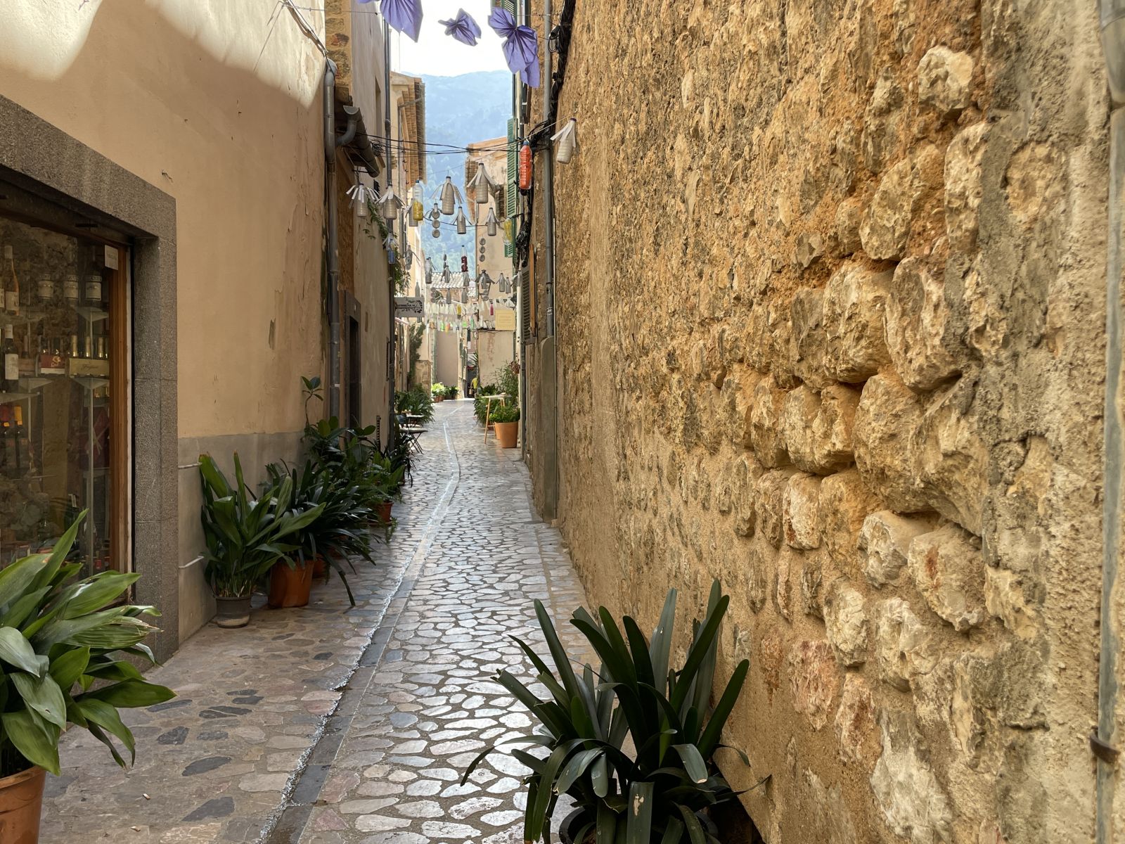 Schmale Naturstein-Gasse in Sóller mit grünen Fensterläden und Pflastersteinen